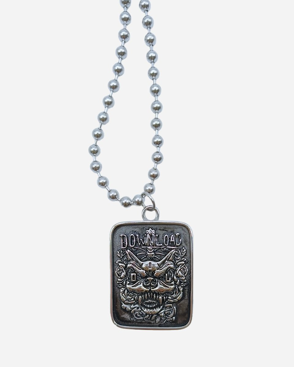 The 2025 Download Wild Rose & Dog Necklace is a silver pendant on a ball chain, featuring an intricate cat face with flowers and DOWNLOAD engraved above.