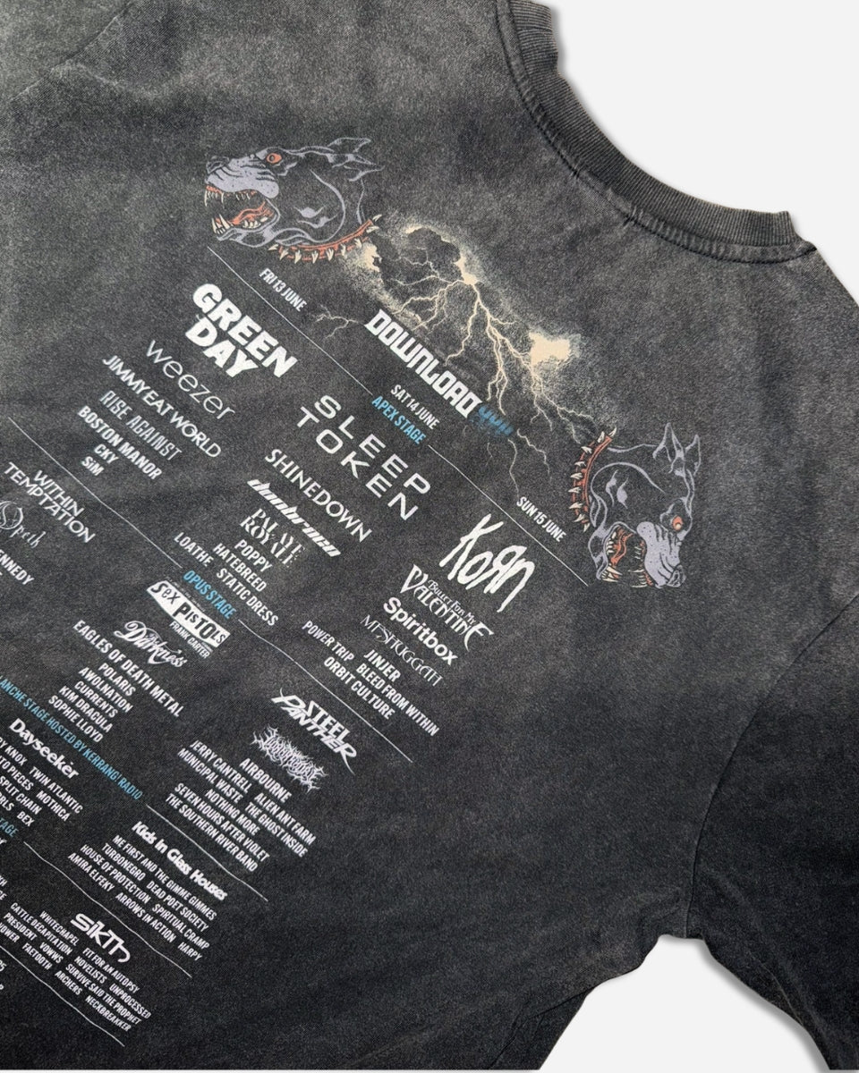The P&Co Cerberus 2025 Event T-Shirt by 2025 is a black tee with the Download Festival lineup on the back—featuring bands like Green Day, Slipknot, and Korn—and bold graphics of dog heads and lightning bolts.