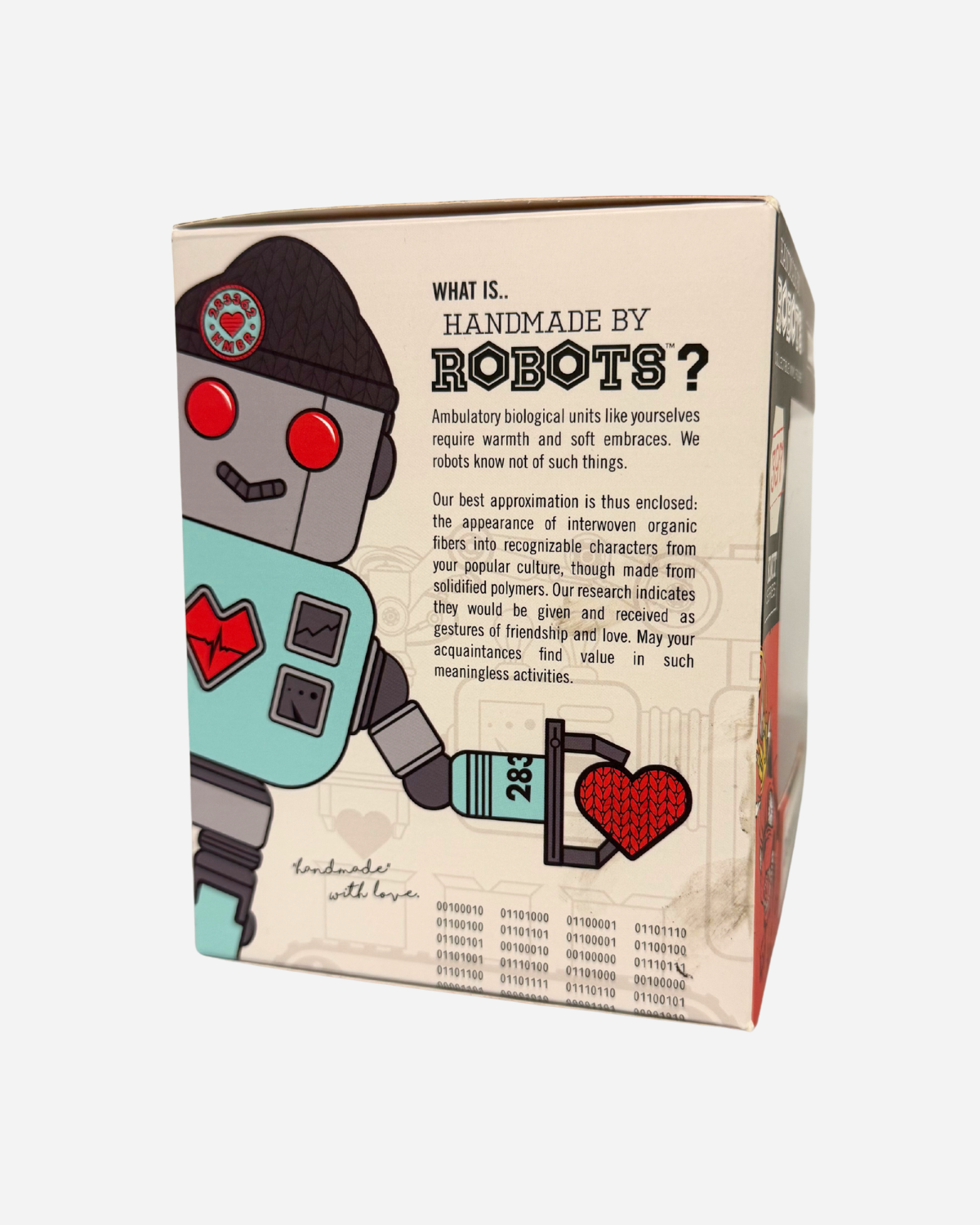 The Hand Made by Robots Download Vinyl Dog from Download 2026 comes in a decorative box featuring a cartoon robot with a beanie holding a red knitted heart, highlighting its collectible design inspired by hand-knit toys.