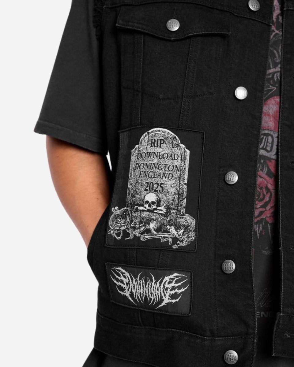 A person wearing the Mary Wyatt Patch Lord Battle Jacket by 2025, featuring a tombstone patch reading RIP Download Donington England 2025 and another patch with an illegible band logo; their arm and part of a black t-shirt are visible.