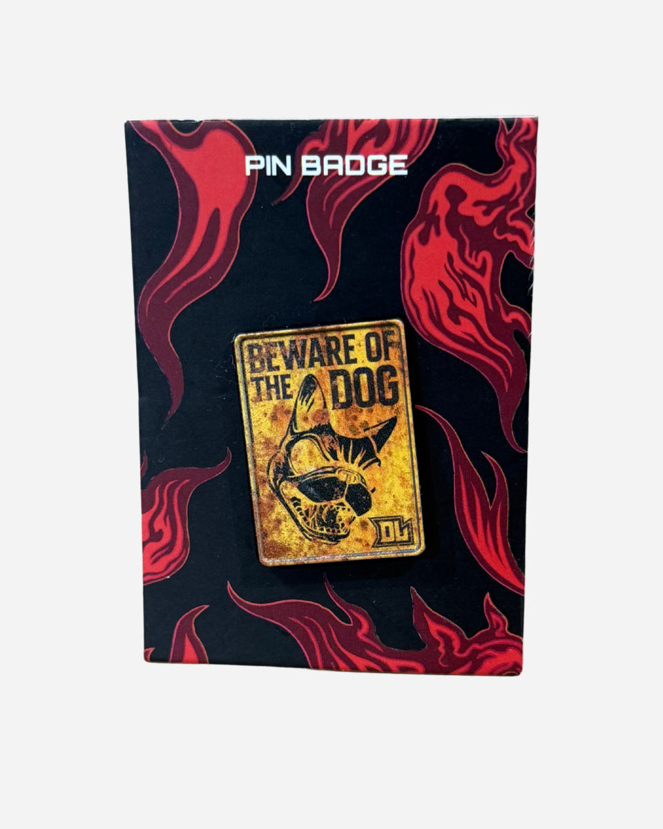A “Beware of the Dog” Pin Badge by Download 2026, featuring a dog illustration on a yellow sign, displayed on a black and red flame-patterned card labeled “PIN BADGE” at the top.