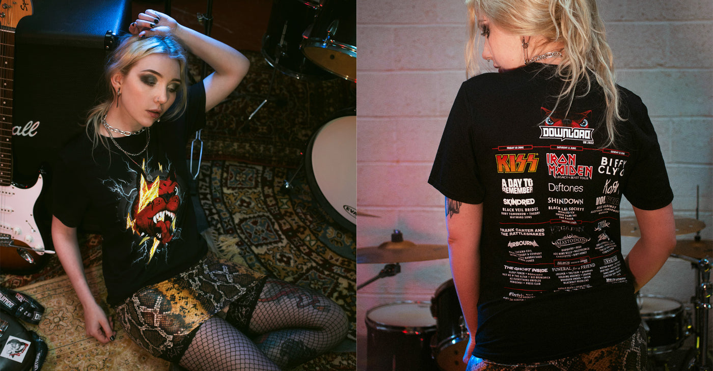 Split-screen web banner for the Download Festival “Retro Collection” made-to-order merchandise. The left side shows a woman wearing a black t-shirt with a red Download Festival dog mascot face, struck by a yellow lightning bolt. The right side shows the back of the same shirt featuring the Download 2022 lineup with band names including KISS, Iron Maiden, and Biffy Clyro. Text overlay in the centre reads “RETRO COLLECTION – Made-to-order – Shop Now.” The scene is set in a music rehearsal space with drum kits