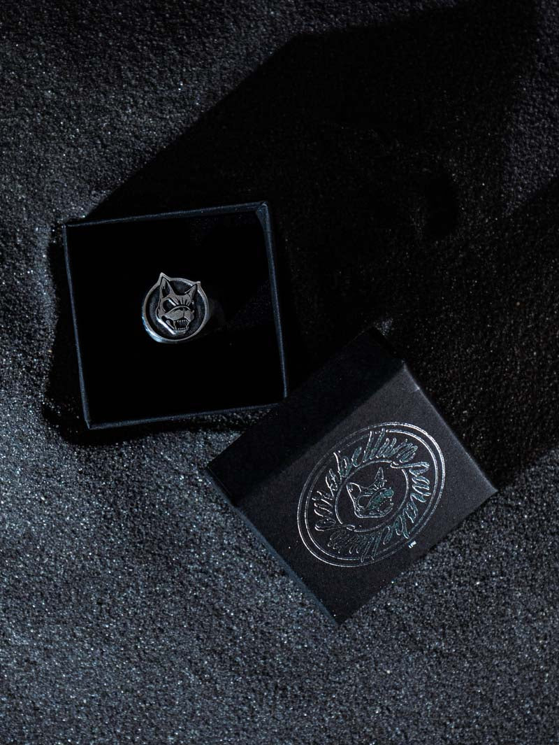 Sterling silver ring featuring an engraved snarling dog face, presented in a branded ParabellumLDN black gift box with metallic silver logo, set against a textured dark background.