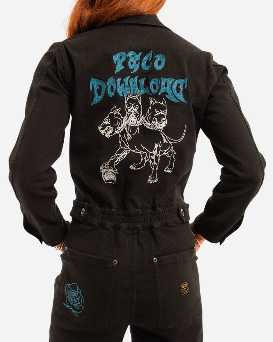 A person wears the 2025 P&CO Long Sleeve Boiler Suit, a black jumpsuit featuring blue embroidery of two fierce dogs and Psyco Downloart on the back, plus a smaller blue design on the pocket.