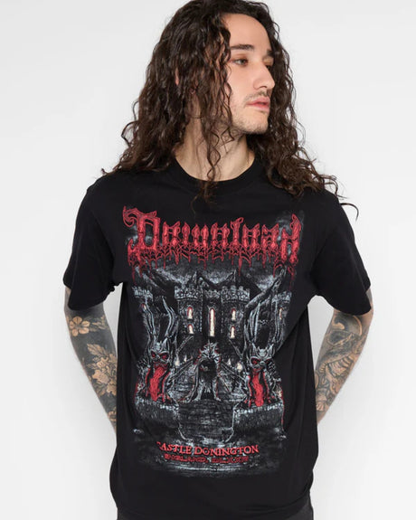 A person with long curly hair and tattooed arms wears a black Mary Wyatt Gatekeeper Line Up T-Shirt by Download 2026, looking to the side against a plain white background.