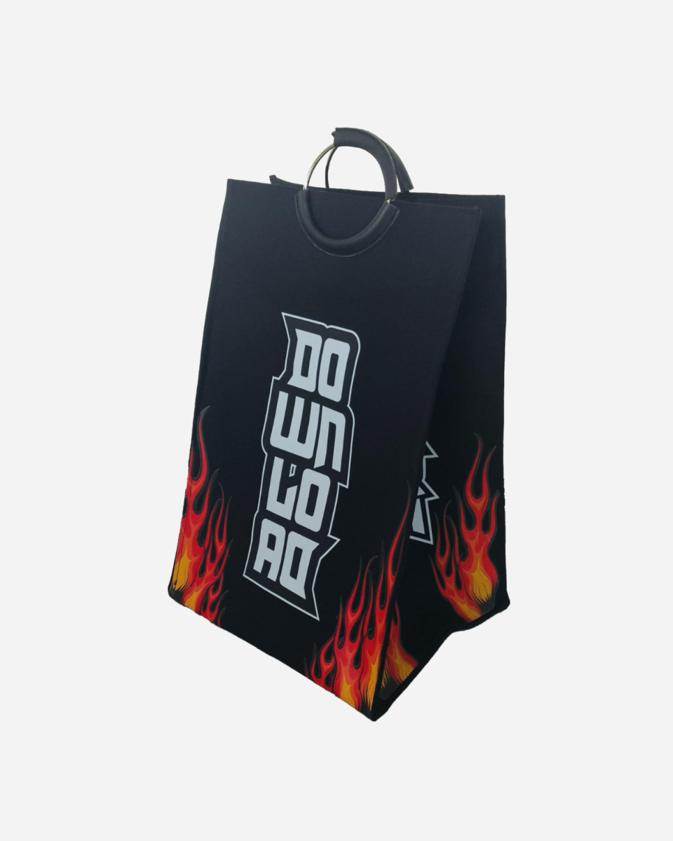 The Wash Pit Laundry Bag by Download 2026 is a black tote with metal handles, bold white "DOWN TO RIDE" text, and a red and yellow flame graphic at the bottom, shown against a plain white background.
