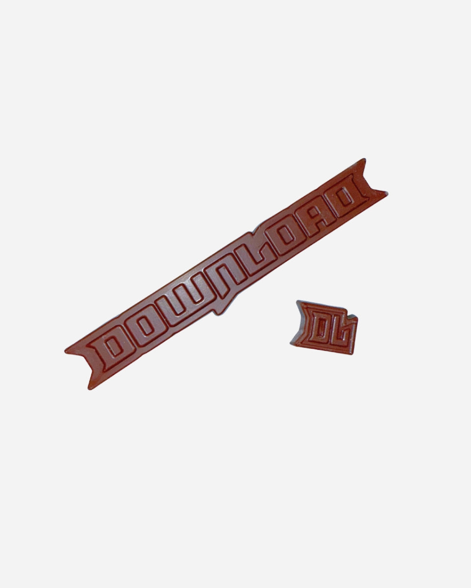 The Download Advent Calendar by 2025 features a brown, stylized "DOWNLOAD" with a matching DL cut-out, both made of solid material, displayed on a plain white background.