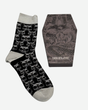 A pair of Beast Socks by Download 2026 with a gray skull pattern, placed next to a coffin-shaped box featuring snake artwork and the text DOWNLOAD on the lid.