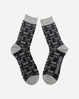 The Beast Socks by Download 2026 are black with gray toes, heels, and cuffs, feature a repeating skull pattern, and have "DOWNLOAD" printed in white on the sole of one sock.