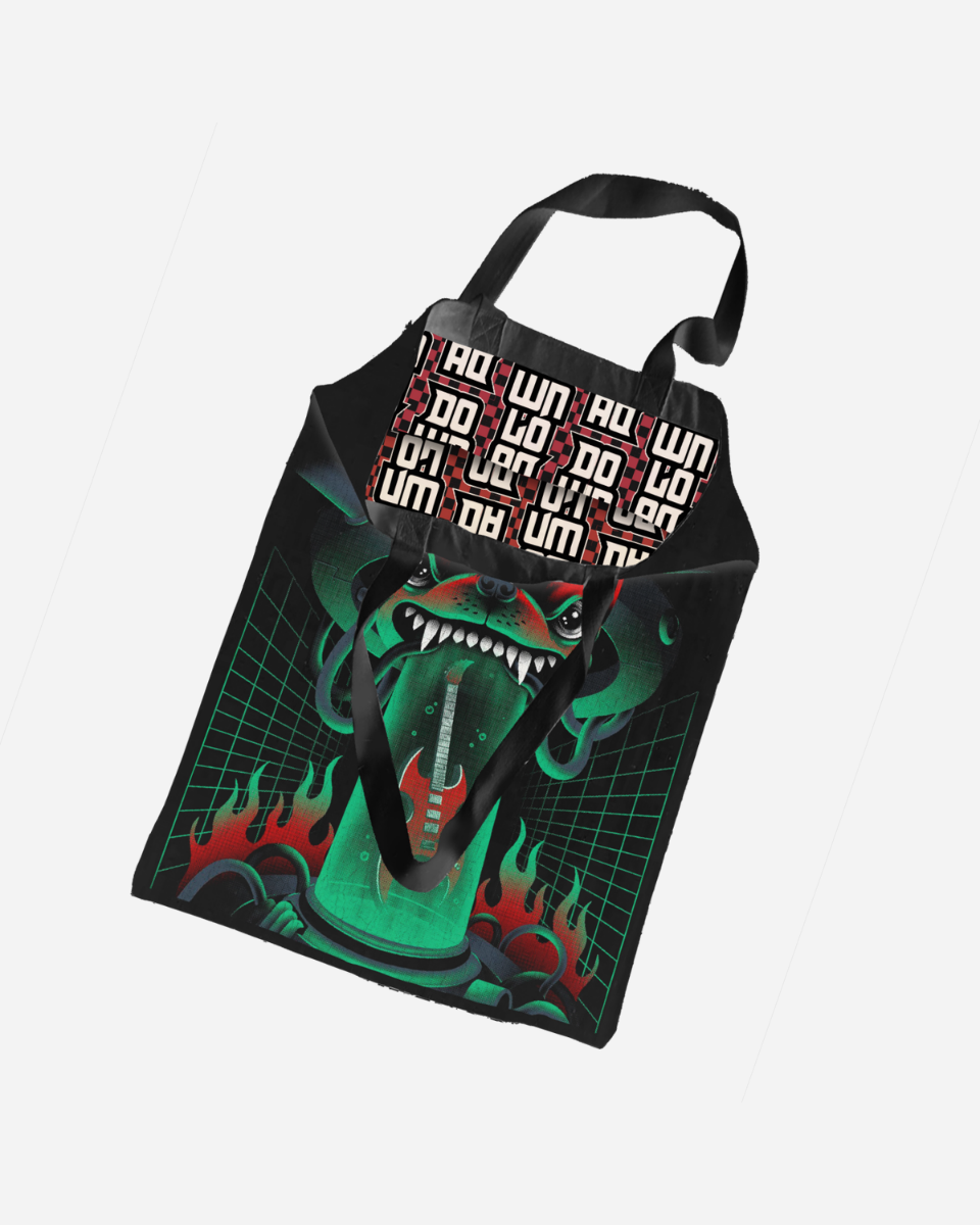 The Neon Fury Tote Bag by Download 2026 is a black tote with a bold green cyborg face, flames, grid lines, and a patterned flap featuring red, white, and black geometric text.